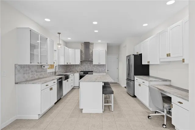 a large white kitchen with a white stove top oven and white cabinets