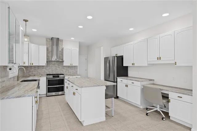 a kitchen with a sink a stove a refrigerator and white cabinets