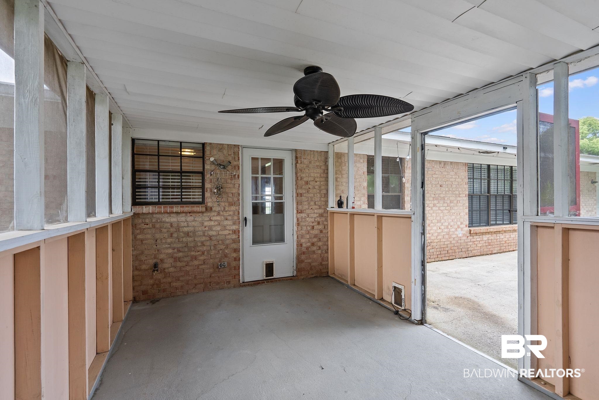 716 North Cedar Street Foley, AL 36535 - Photo 19 of 25 Screened porch featuring a ceiling fan, concrete flooring, and direct access to the exterior