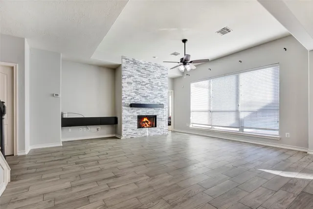 wooden floor fireplace and windows in an empty room
