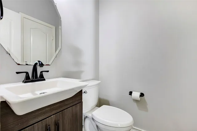 a bathroom with a sink a toilet and mirror