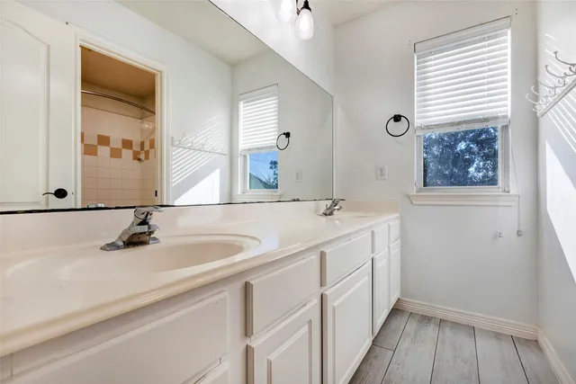 a bathroom with a double vanity sink and a mirror