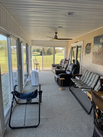 a living room with furniture a rug and a large window