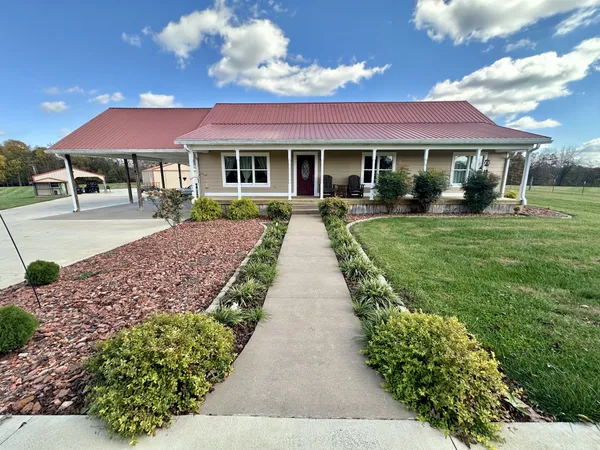 a front view of a house with yard swimming pool and outdoor seating