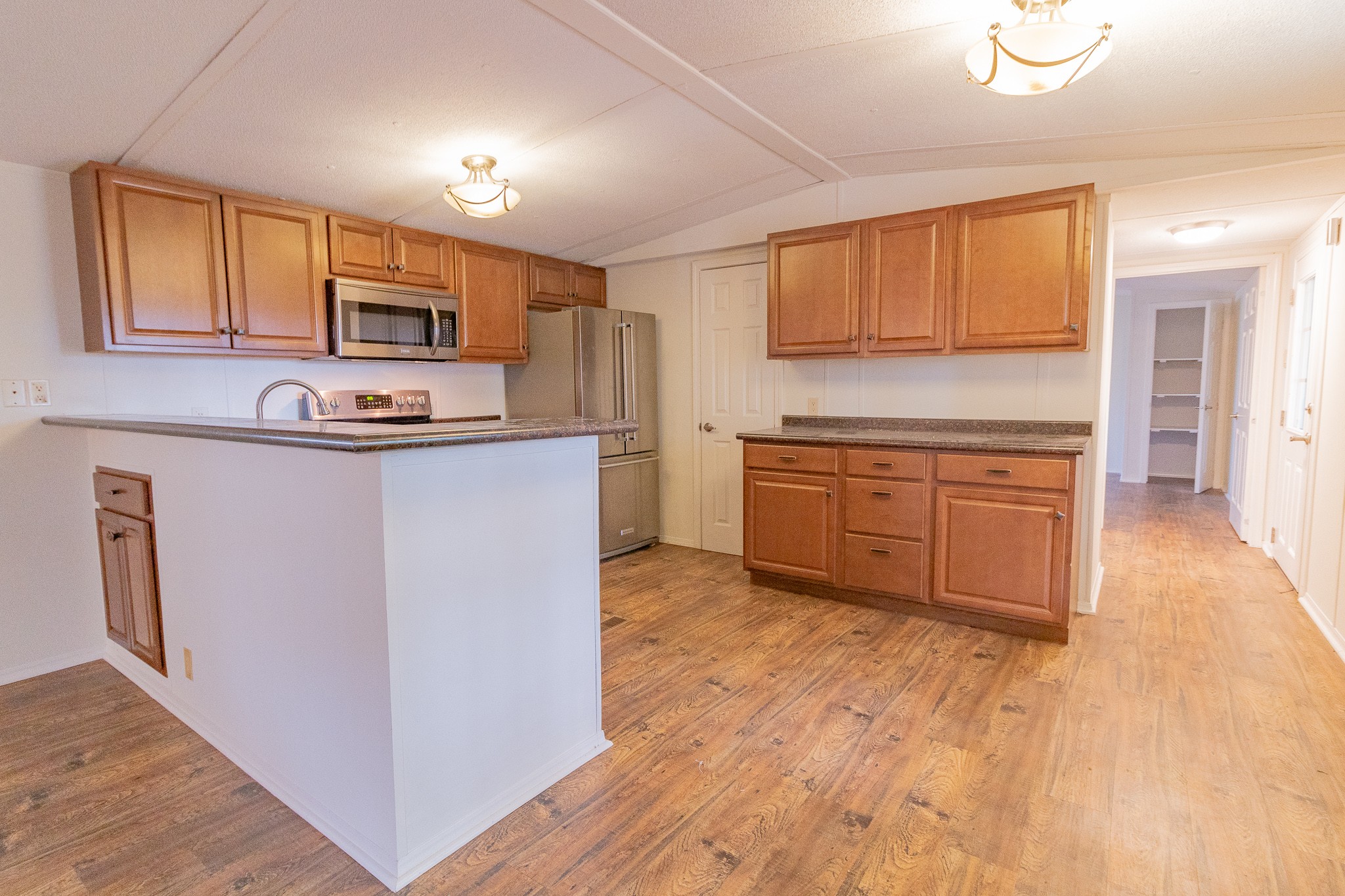 833 Speck Road Lebanon, TN 37087 - Photo 9 of 40 a kitchen with stainless steel appliances granite countertop a stove top oven a sink dishwasher and a microwave oven with wooden floor