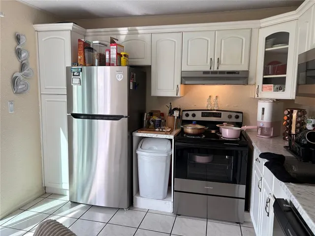 a kitchen with granite countertop a sink a stove and cabinets