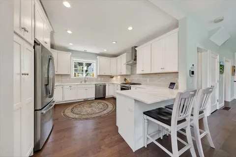 a kitchen with stainless steel appliances kitchen island granite countertop a refrigerator and a stove top oven