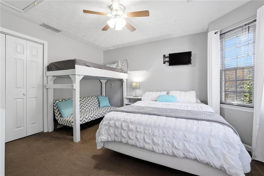 3341 Danielle Way Suwanee, GA 30024 - Photo 26 of 39 a bedroom with a bed and a chandelier