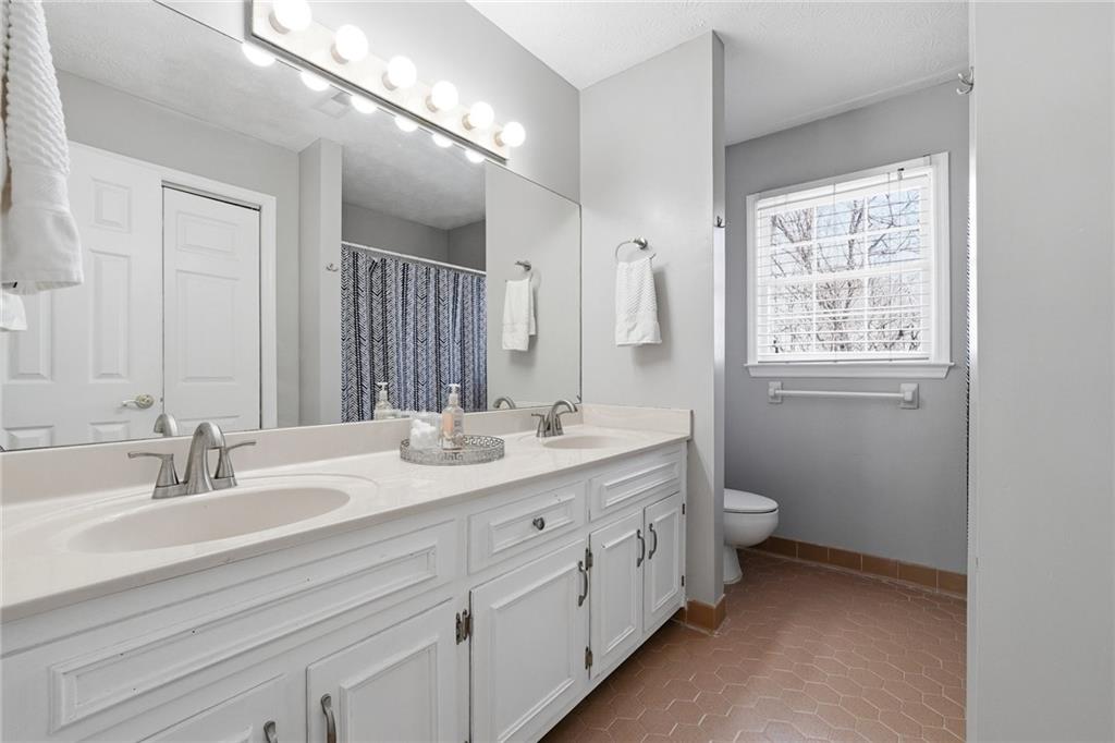 3341 Danielle Way Suwanee, GA 30024 - Photo 27 of 39 a bathroom with a double vanity sink toilet and a window
