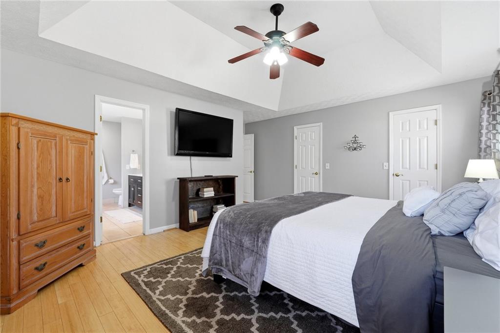 3341 Danielle Way Suwanee, GA 30024 - Photo 6 of 39 a spacious bedroom with a bed and a flat screen tv