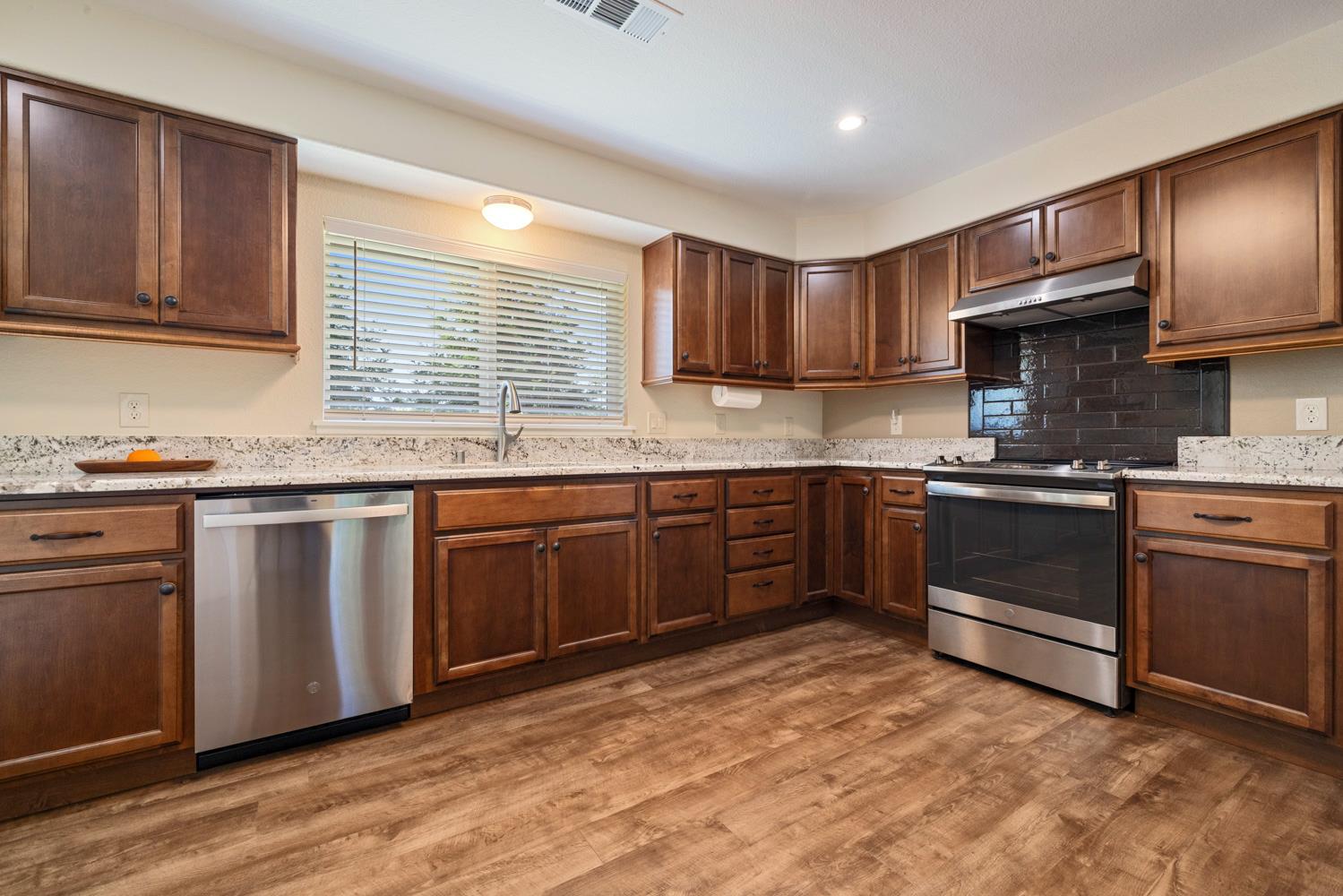 1255 Root Road Modesto, CA 95357 - Photo 21 of 52 a kitchen with stainless steel appliances granite countertop a stove sink and cabinets
