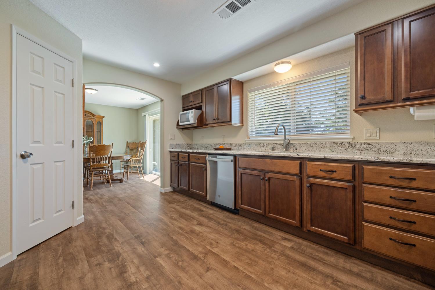1255 Root Road Modesto, CA 95357 - Photo 23 of 52 a kitchen with granite countertop a stove a sink and a refrigerator