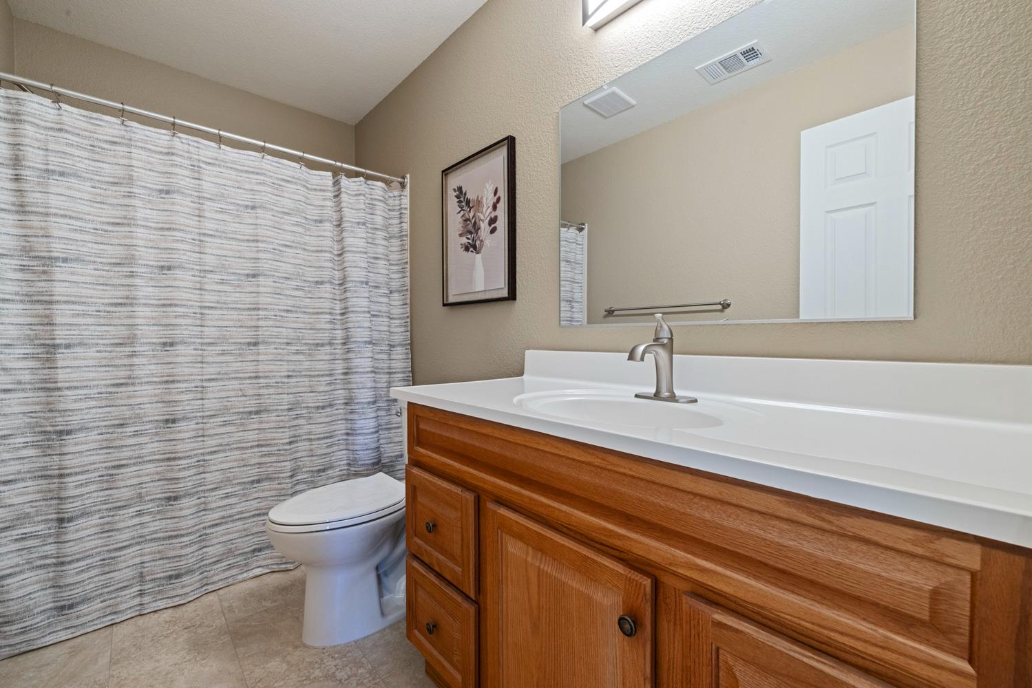 1255 Root Road Modesto, CA 95357 - Photo 27 of 52 a bathroom with a toilet a sink and mirror