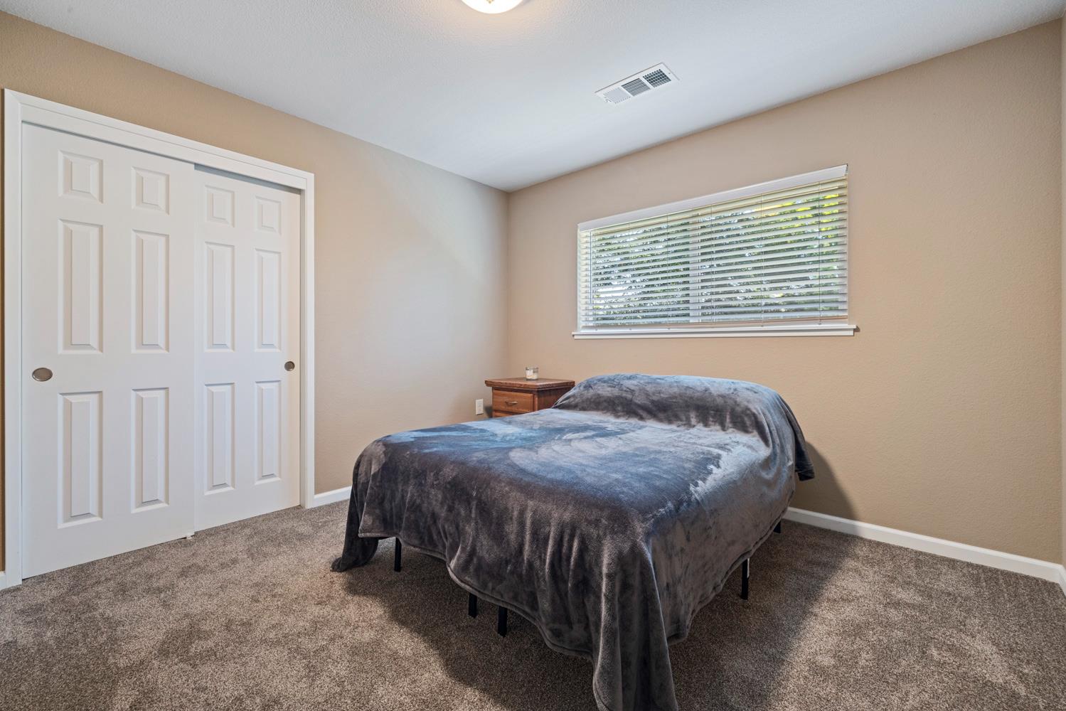 1255 Root Road Modesto, CA 95357 - Photo 29 of 52 a bed sitting in a bedroom next to a window