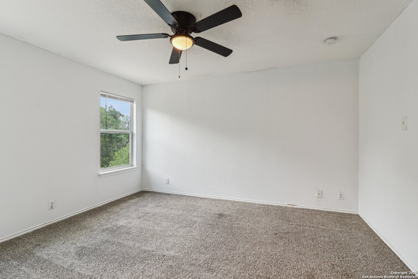 87 Kenrock Ridge San Antonio, TX 78254 - Photo 32 of 50 an empty room with a window and a fan