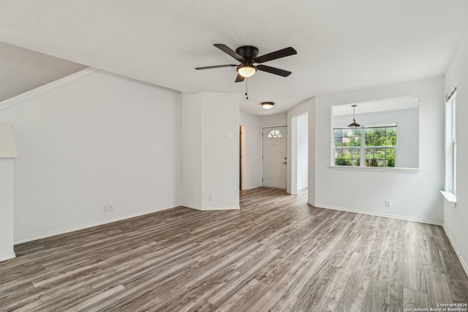 87 Kenrock Ridge San Antonio, TX 78254 - Photo 10 of 50 an empty room with wooden floor ceiling fan and windows