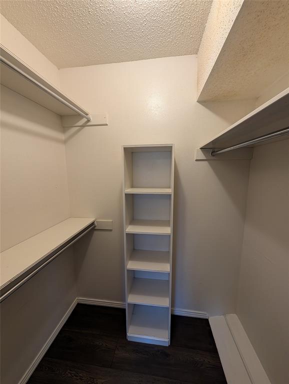 4715 Skillman Street, Unit A Dallas, TX 75206 - Photo 16 of 28 Spacious closet with dark wood-finish flooring, white walls, and built-in shelving
