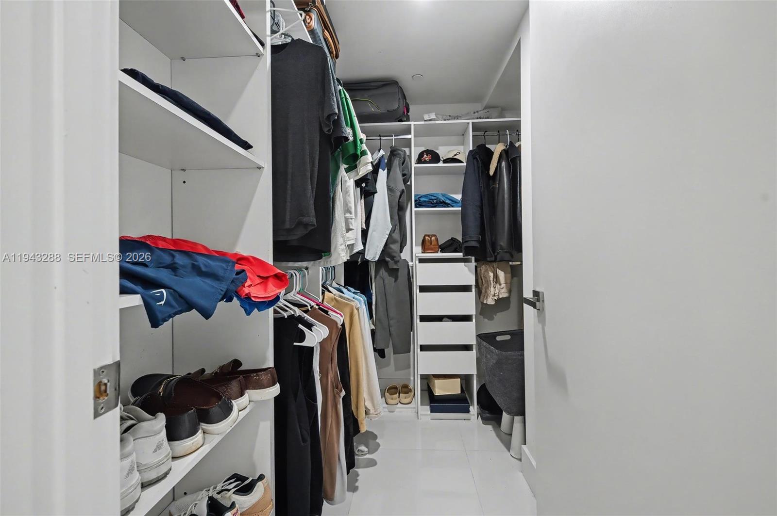 1080 Brickell Avenue, Unit 209 Miami, FL 33131 - Photo 16 of 37 a view of walk in closet with clothes and shoes