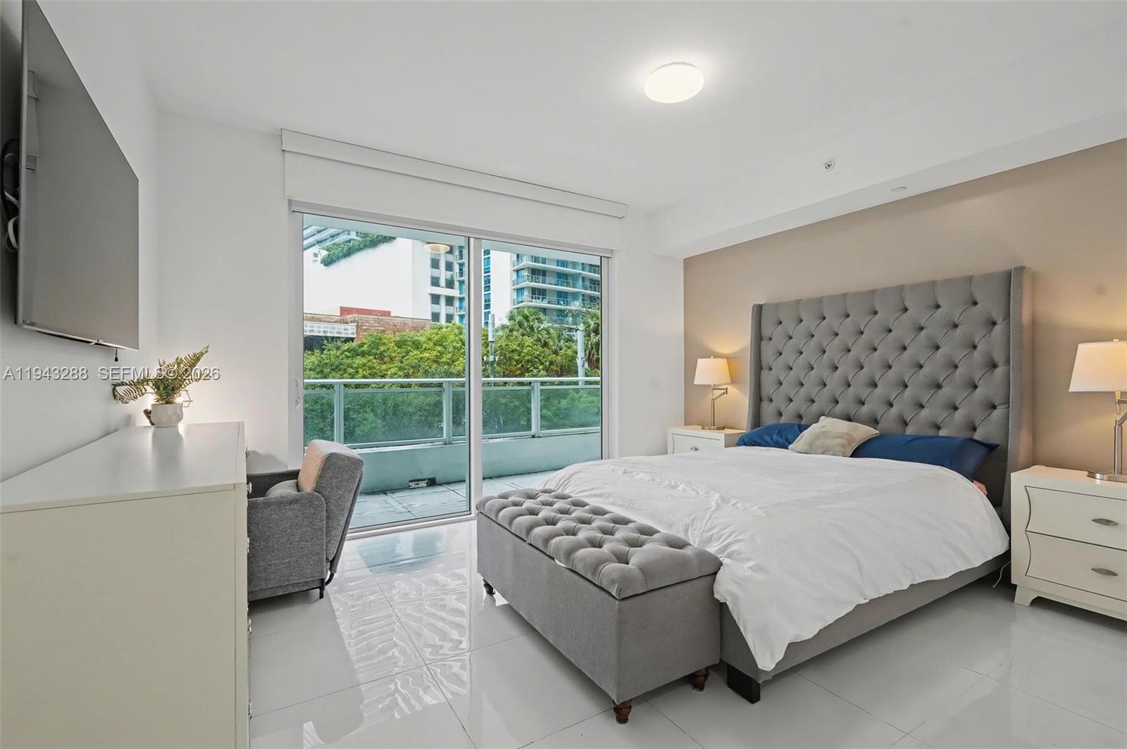 1080 Brickell Avenue, Unit 209 Miami, FL 33131 - Photo 21 of 37 a bedroom with a bed and a large window
