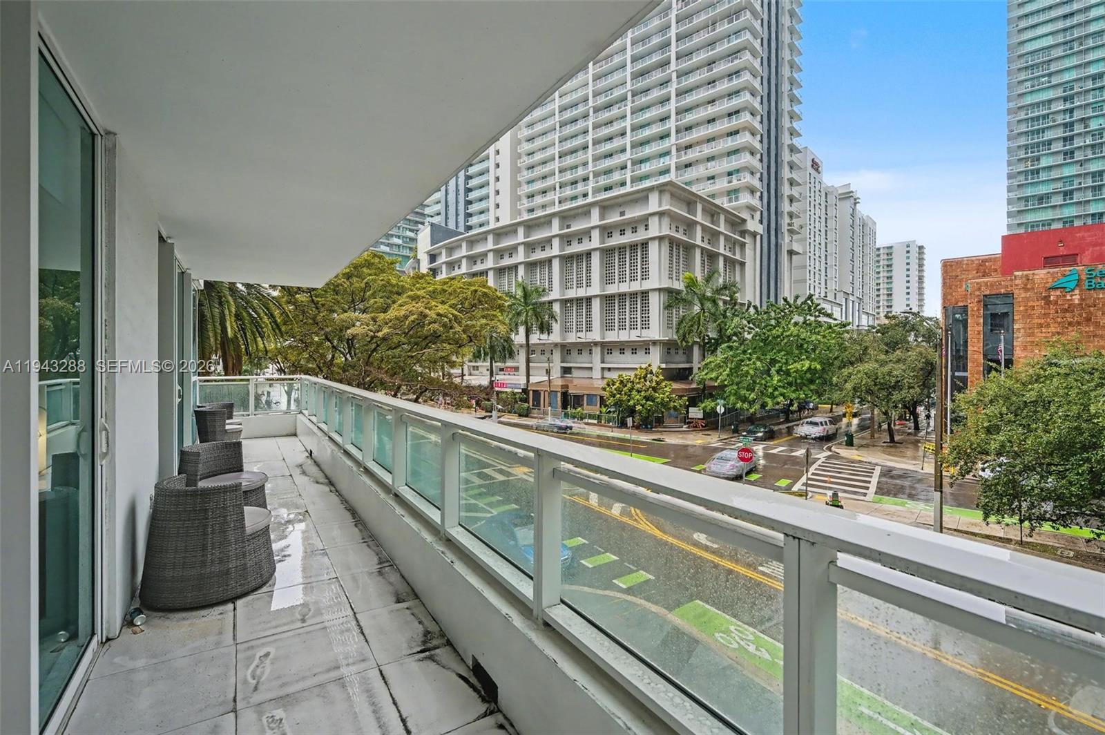 1080 Brickell Avenue, Unit 209 Miami, FL 33131 - Photo 26 of 37 a view of balcony with a couple of cars parked in front of a house