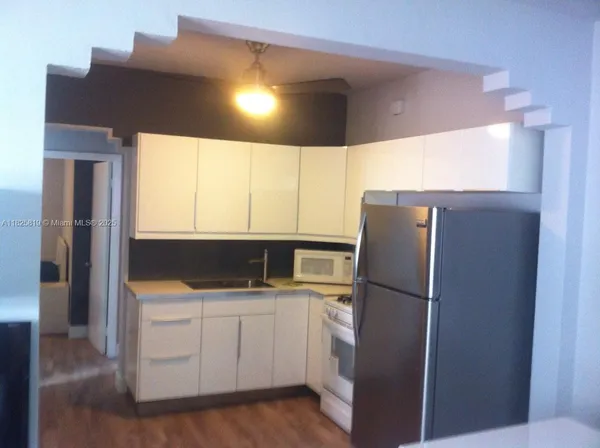 a kitchen with a refrigerator and a sink