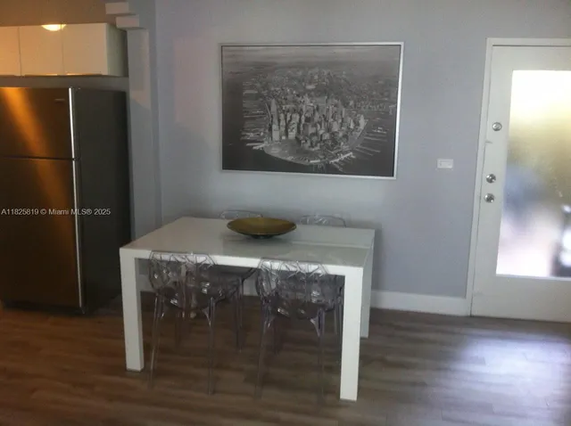 a kitchen with a wooden floor and a refrigerator