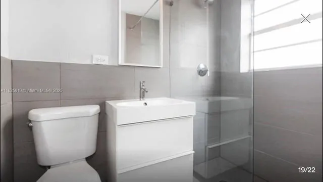 a bathroom with a toilet sink and mirror