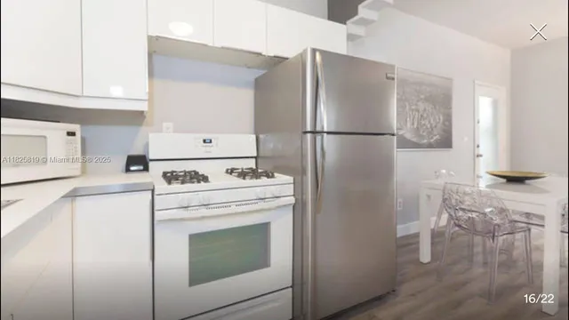 a kitchen with stainless steel appliances white cabinets and a refrigerator