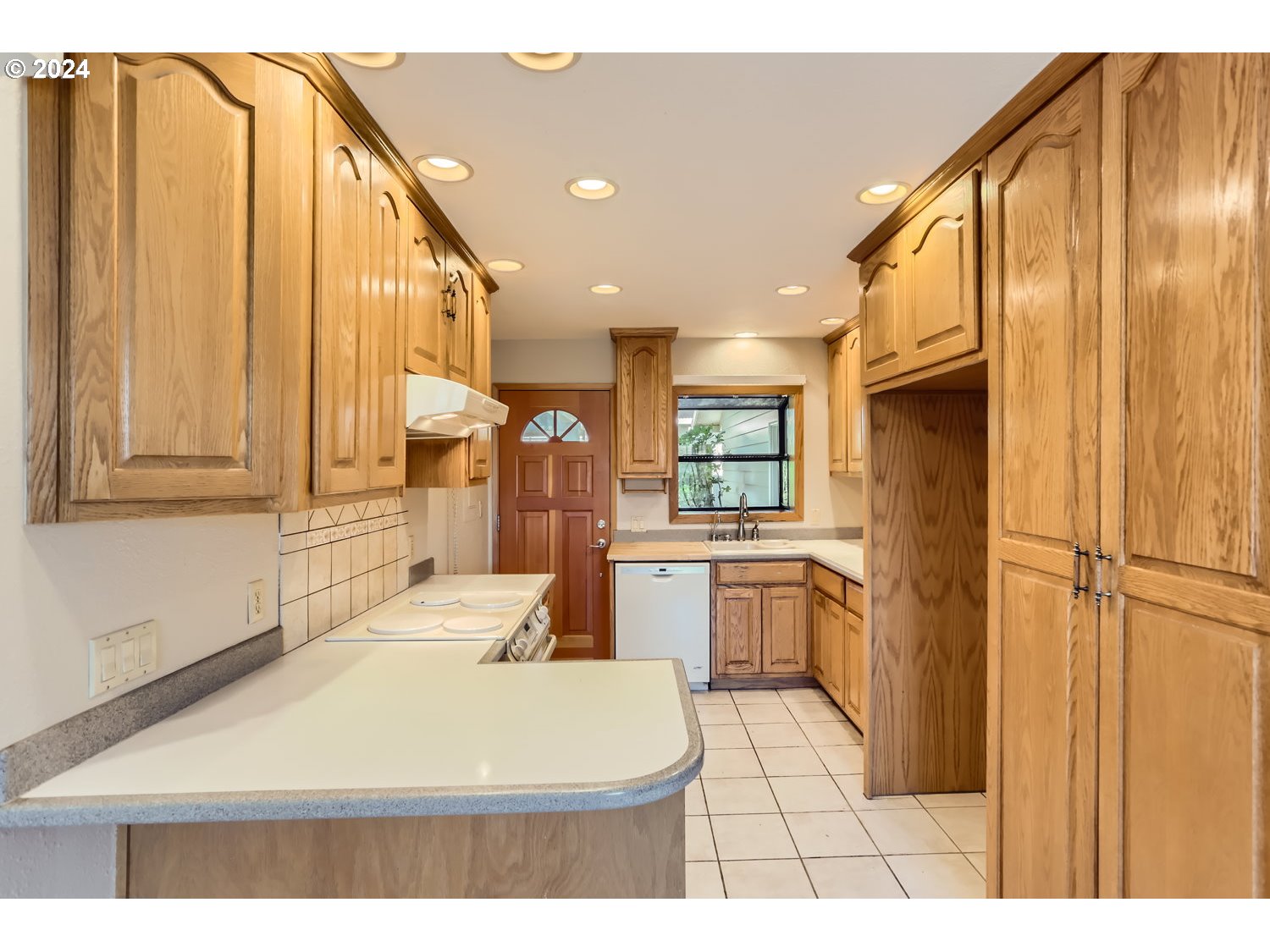 4009 Southeast View Acres Road Milwaukie, OR 97267 - Photo 11 of 37 a kitchen with a refrigerator a sink dishwasher with a dining table and chairs