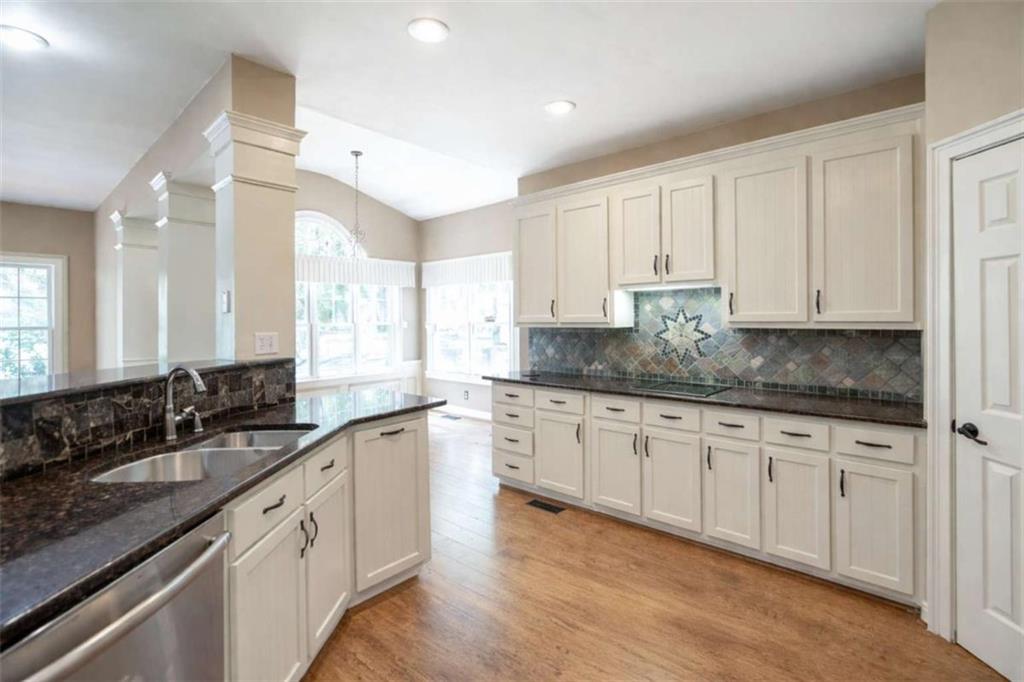 1660 A Maple Ridge Drive Loganville, GA 30052 - Photo 23 of 51 a large kitchen with granite countertop a sink white cabinets and white stainless steel appliances