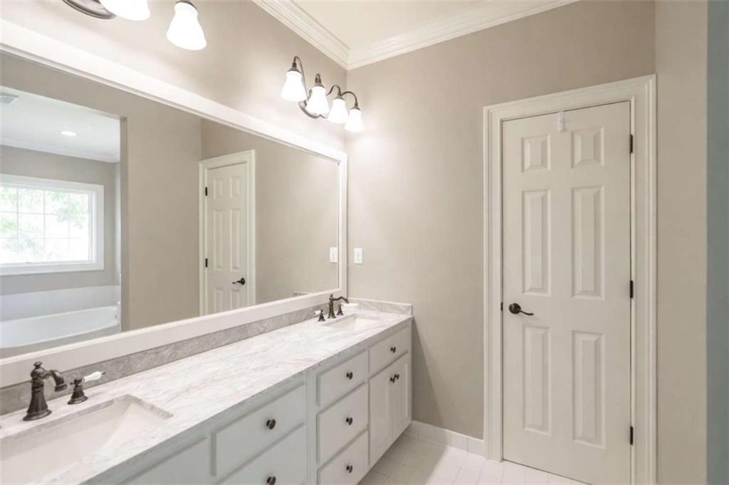 1660 A Maple Ridge Drive Loganville, GA 30052 - Photo 28 of 51 a bathroom with double vanity sink a vanity and a mirror