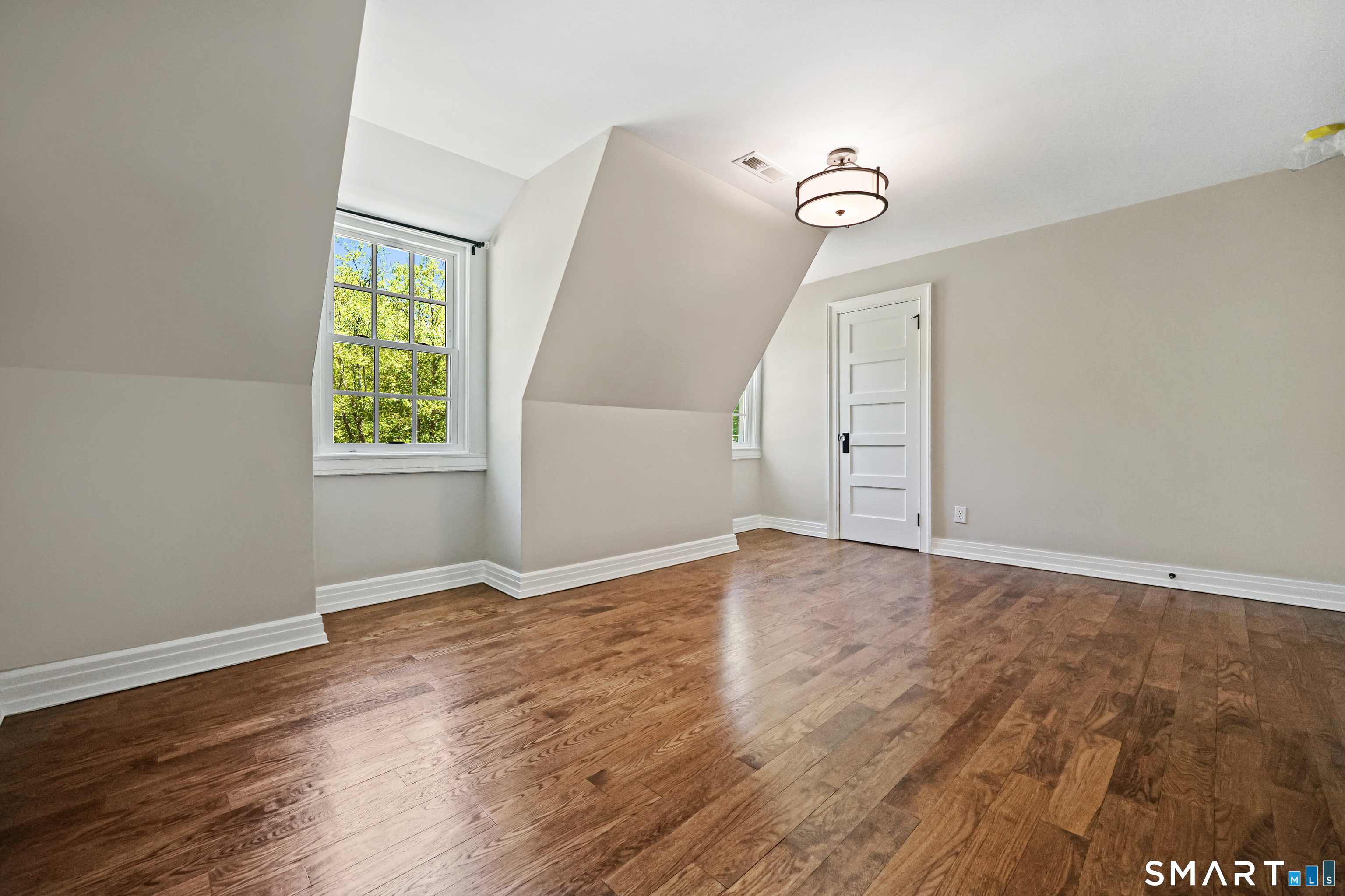4 Old Barlow Mountain Road Ridgefield, CT 06877 - Photo 27 of 40 an empty room with wooden floor and windows