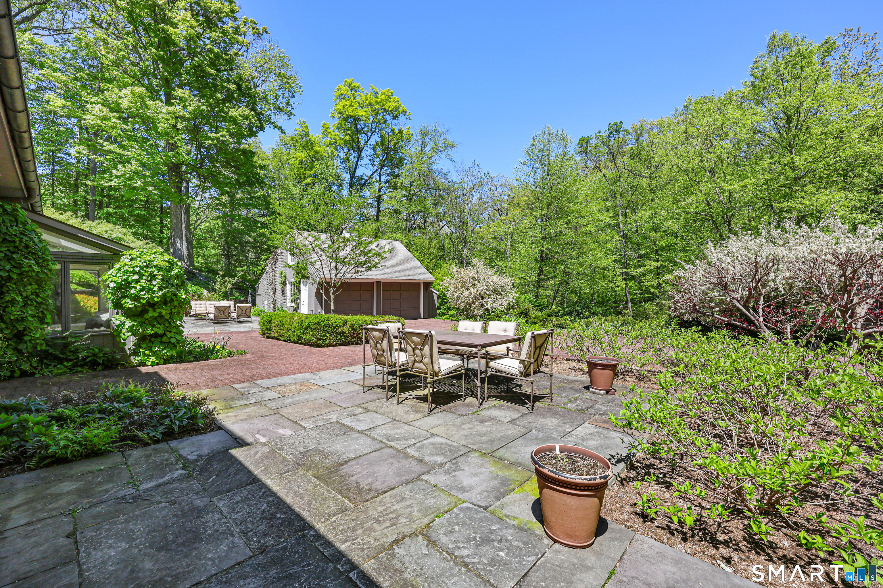 4 Old Barlow Mountain Road Ridgefield, CT 06877 - Photo 35 of 40 a view of a patio with table and chairs potted plants with sky view