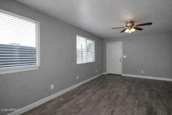 a view of a room with a ceiling fan and window