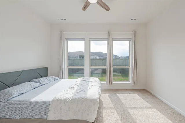 a bedroom with a large bed and a large window