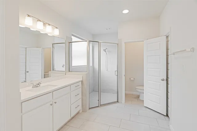 a spacious bathroom with a shower sink and mirror