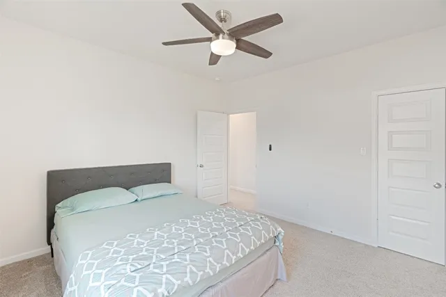 a bedroom with a bed and a ceiling fan