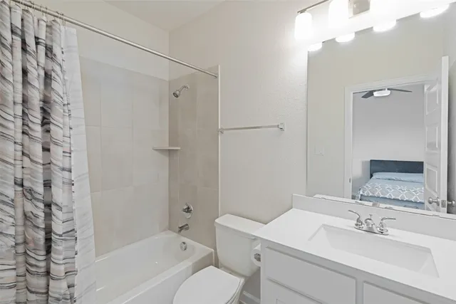 a bathroom with a sink toilet vanity and shower