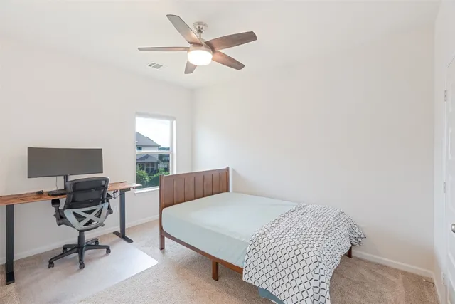 a bedroom with a bed a chair and a large window