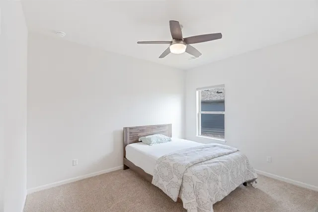 a bedroom with a bed and a ceiling fan