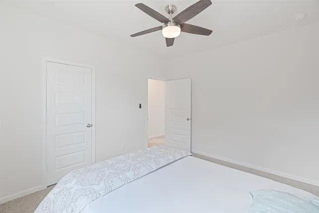 an empty room with closet and fan