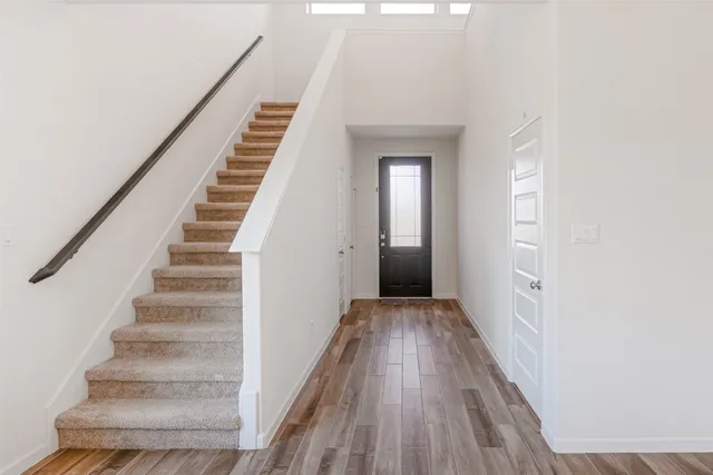 a view of a hallway with wooden floor and entryway