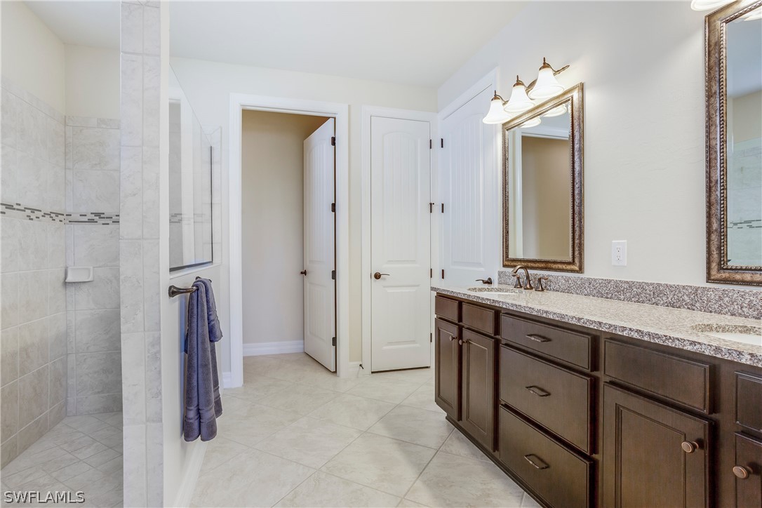 10828 Rutherford Road Fort Myers, FL 33913 - Photo 14 of 31 a spacious bathroom with a granite countertop sink mirror and a