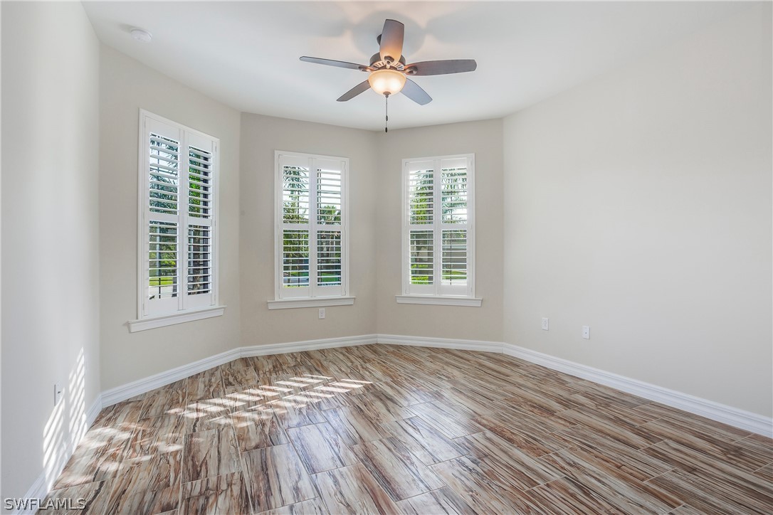 10828 Rutherford Road Fort Myers, FL 33913 - Photo 16 of 31 a view of empty room with wooden floor and fan