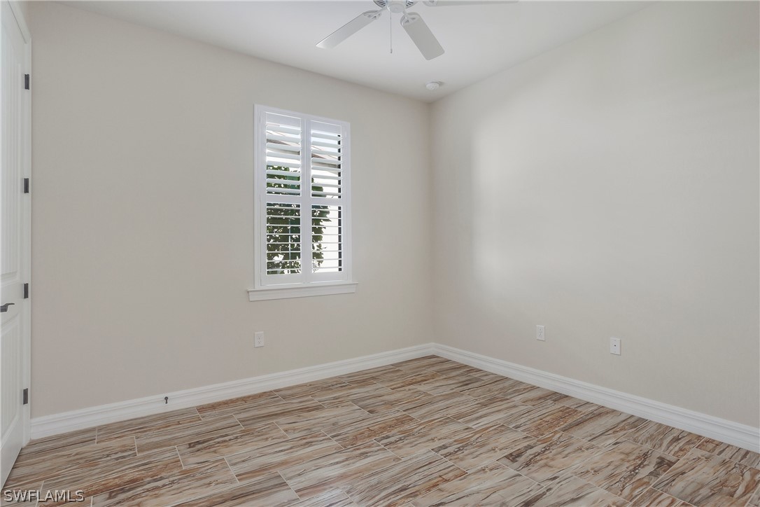 10828 Rutherford Road Fort Myers, FL 33913 - Photo 18 of 31 wooden floor in an empty room with a window