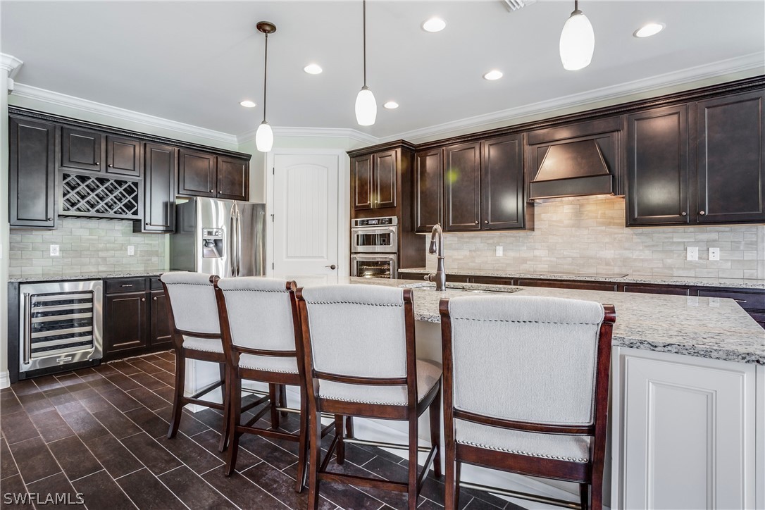 10828 Rutherford Road Fort Myers, FL 33913 - Photo 5 of 31 a kitchen with a table chairs refrigerator and cabinets