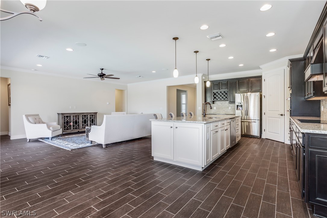 10828 Rutherford Road Fort Myers, FL 33913 - Photo 8 of 31 a large white room with kitchen view and a fireplace
