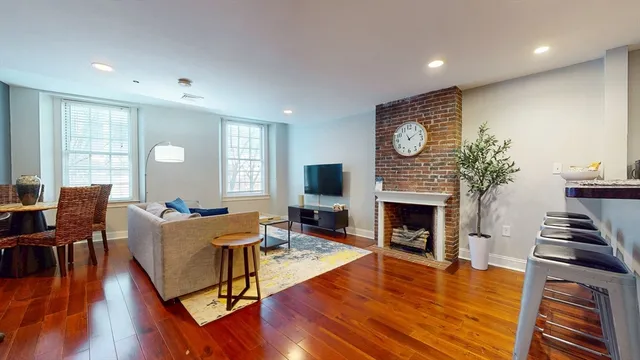 a living room with furniture fireplace wooden floor and a fireplace