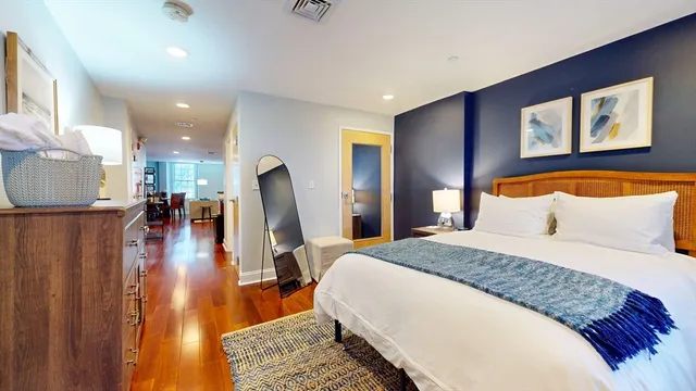 a spacious bedroom with a bed and a view of living room