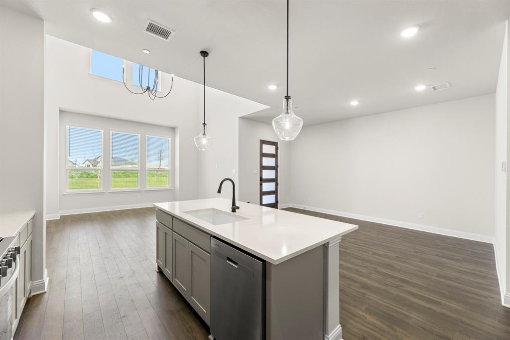 3916 Keya Drive Prosper, TX 75078 - Photo 6 of 28 a kitchen with a sink chandelier and wooden floor